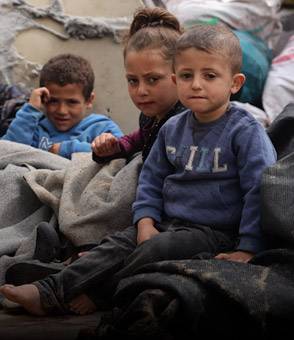 Niños durante su desplazamiento en Rafah Niños sentados en la parte trasera de un camión