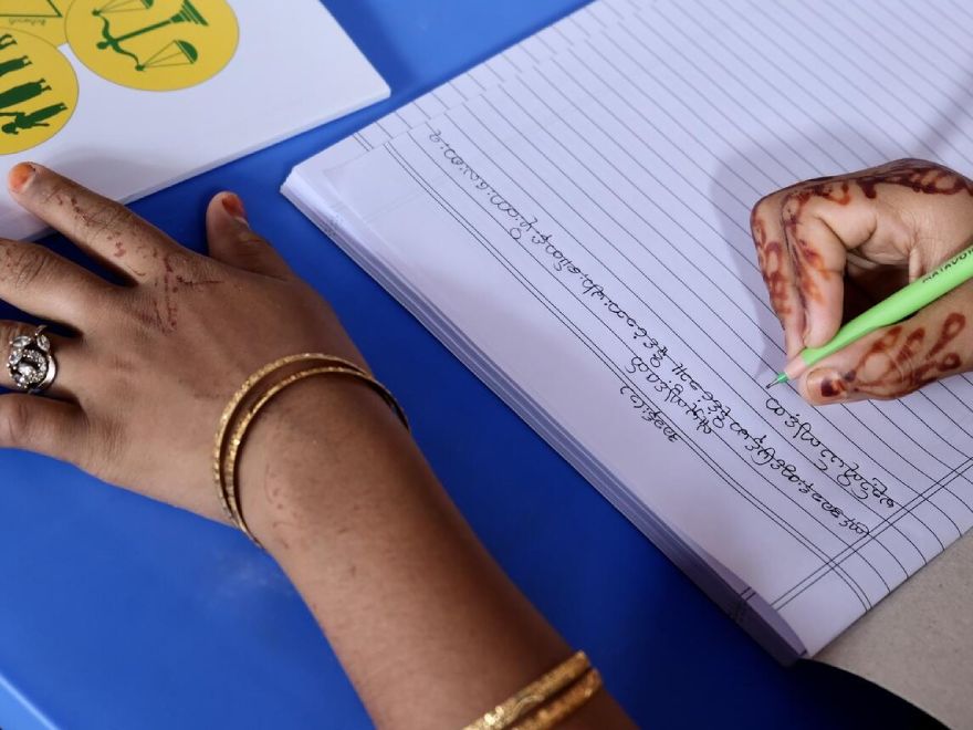 Una joven rohingya practica la escritura de la lengua birmana, originaria de Myanmar