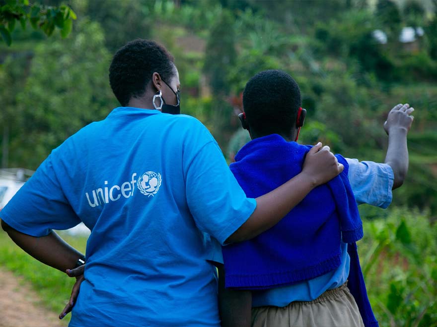 Imagen de una trabajadora de UNICEF junto a un niño con discapacidad