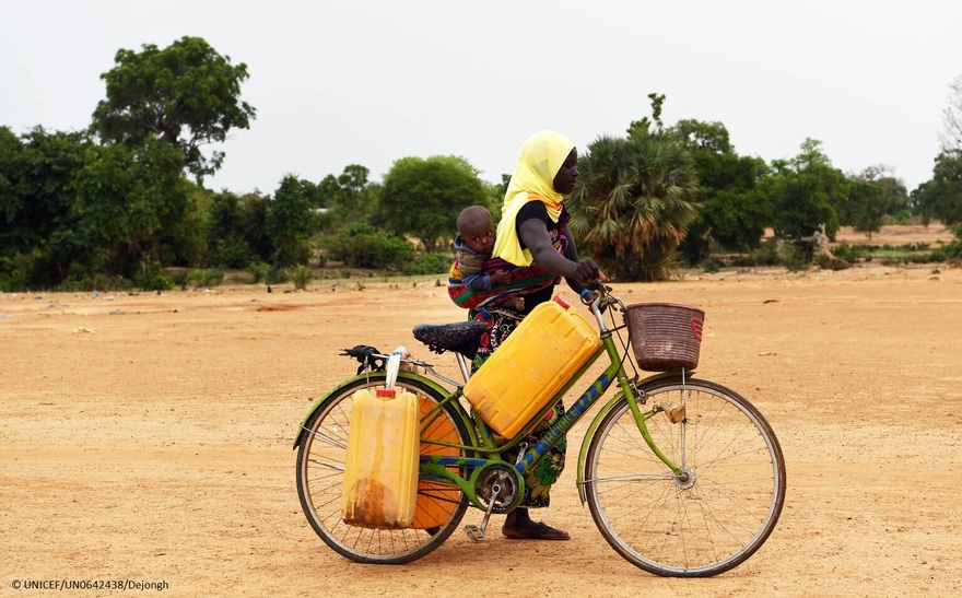 Una mujer con su hijo camino a un pozo, en Fada, en el este de Burkina Faso.