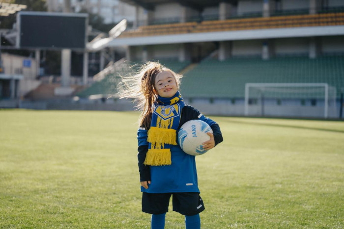 Maricica juega al fútbol con otros niños y niñas en Moldavia.