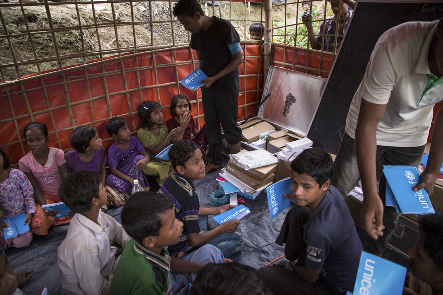Imagen de niños y niñas rohingya recibiendo material escolar