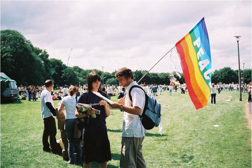 Imagen de dos jóvenes junto a la bandera de la paz
