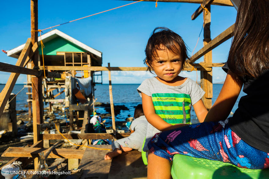 Un niño filipino enfrente del hogar familiar que ya han empezado a reconstruir