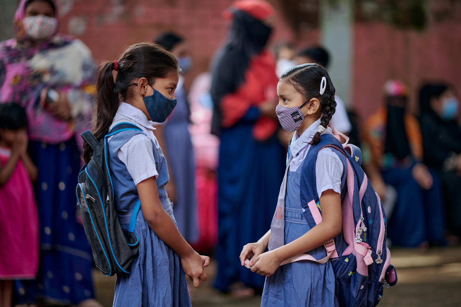 Dos amigas conversan después de conocerse en persona, un año después en la Escuela Primaria Gubernamental Gandaria Mohila Shomity, Dhaka, Bangladesh, el 12 de septiembre de 2021.