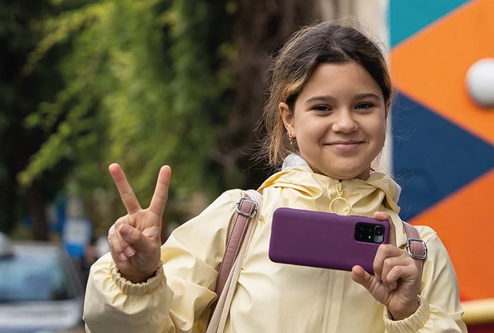 Una niña posa con su móvil mientras hace una foto. Portada del Informe sobre el impacto de la tecnología en la infancia y la adolescencia de UNICEF España