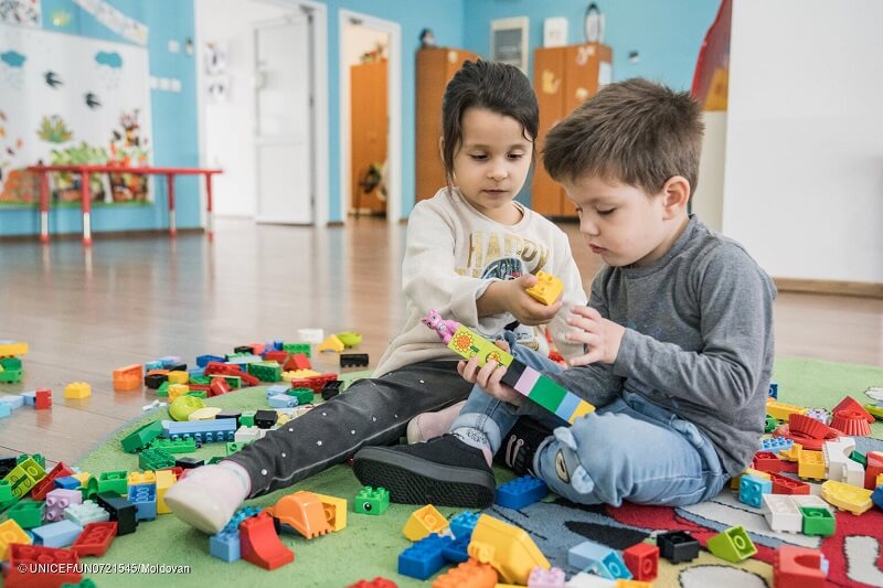 Ilinca, niña rumana de 5 años, ayuda a Karim, niño ucraniano de 3 años, a construir una torre con ladrillos LEGO en el centro Play, learning and parenting de Bucarest el 10 de octubre de 2022.