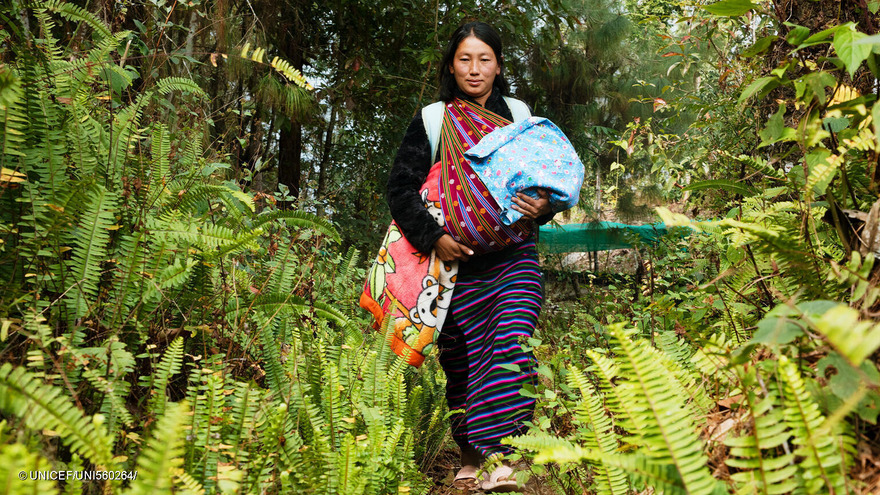 Sangay, de 29 años, camina por el bosque hasta la clínica para vacunar a su hijo recién nacido. Tiene que caminar durante una hora para llegar a la clínica.