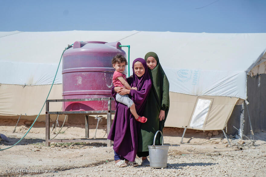 Niñas sirias recogiendo agua de uno de los depósitos instalados con el apoyo de UNICEF