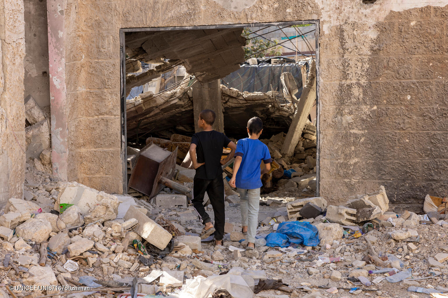 Niños y niñas frente a los escombros de un ataque en la Franja de Gaza