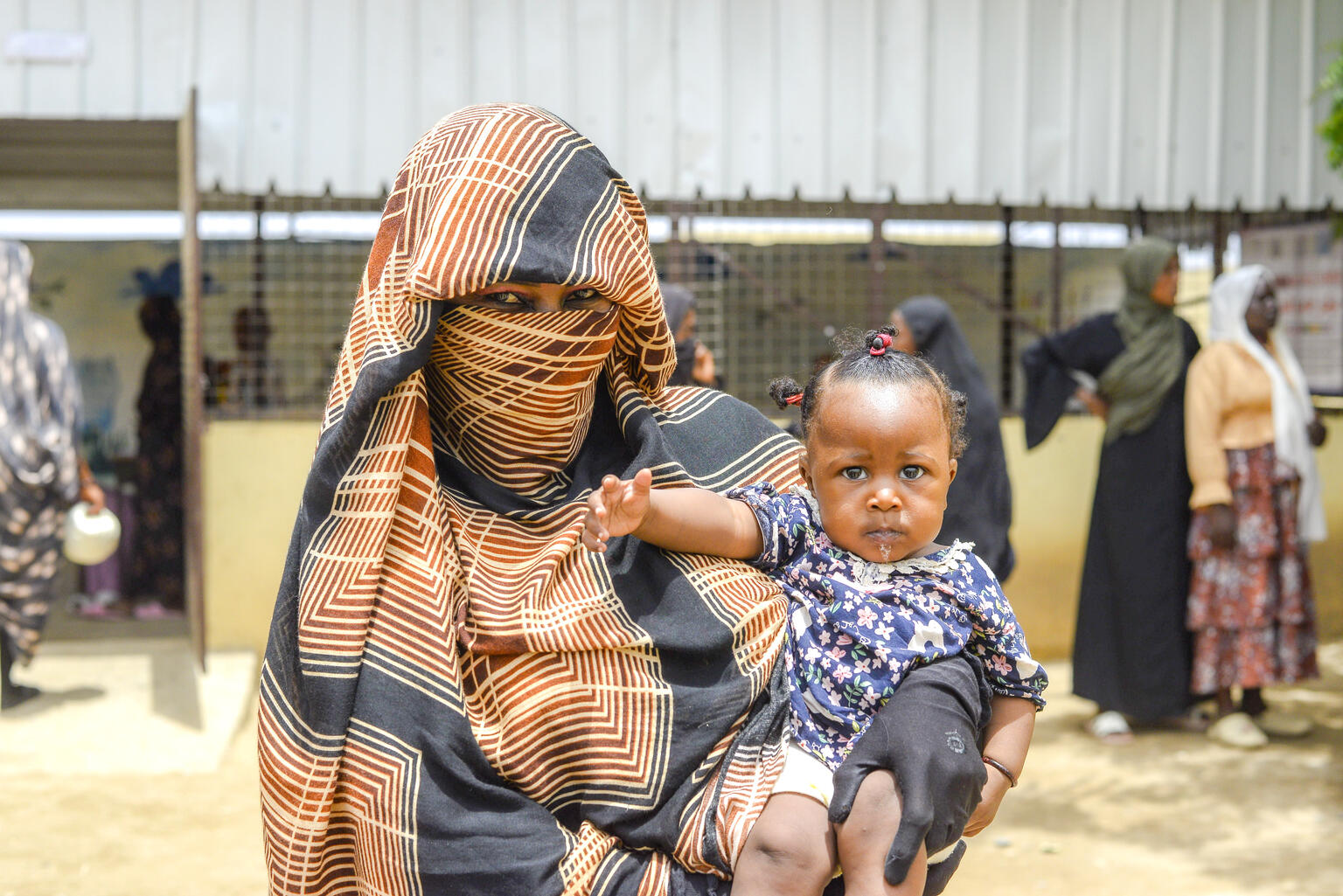 mujer en Sudán con un bebé en brazos