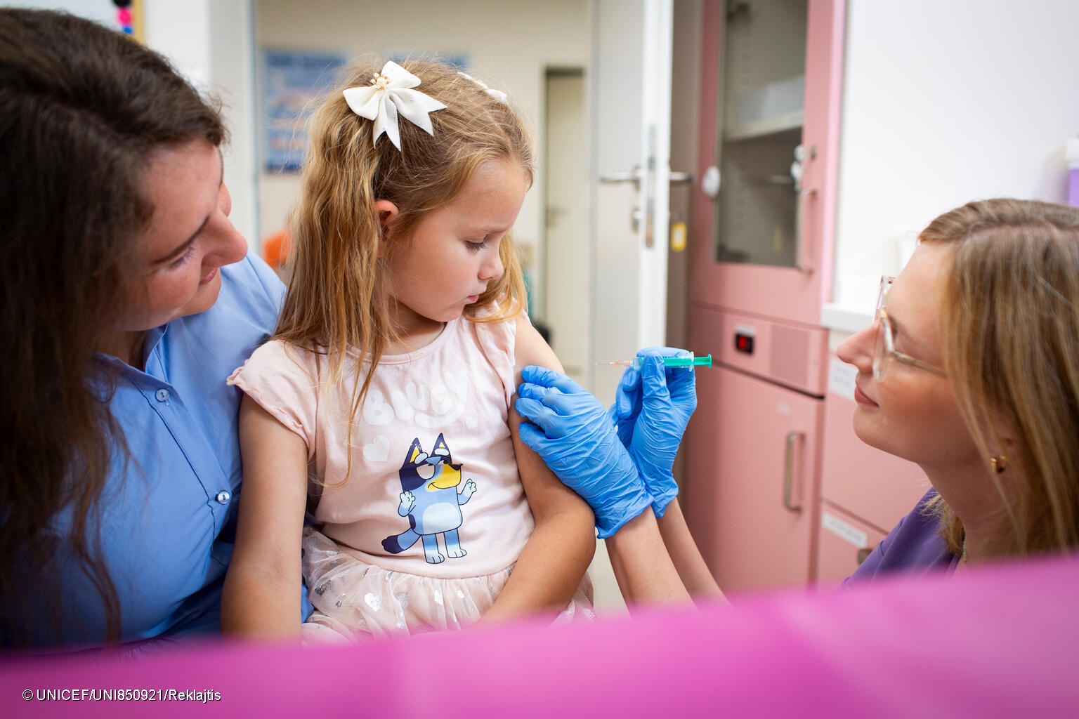 niña recibiendo una vacuna, en Polonia