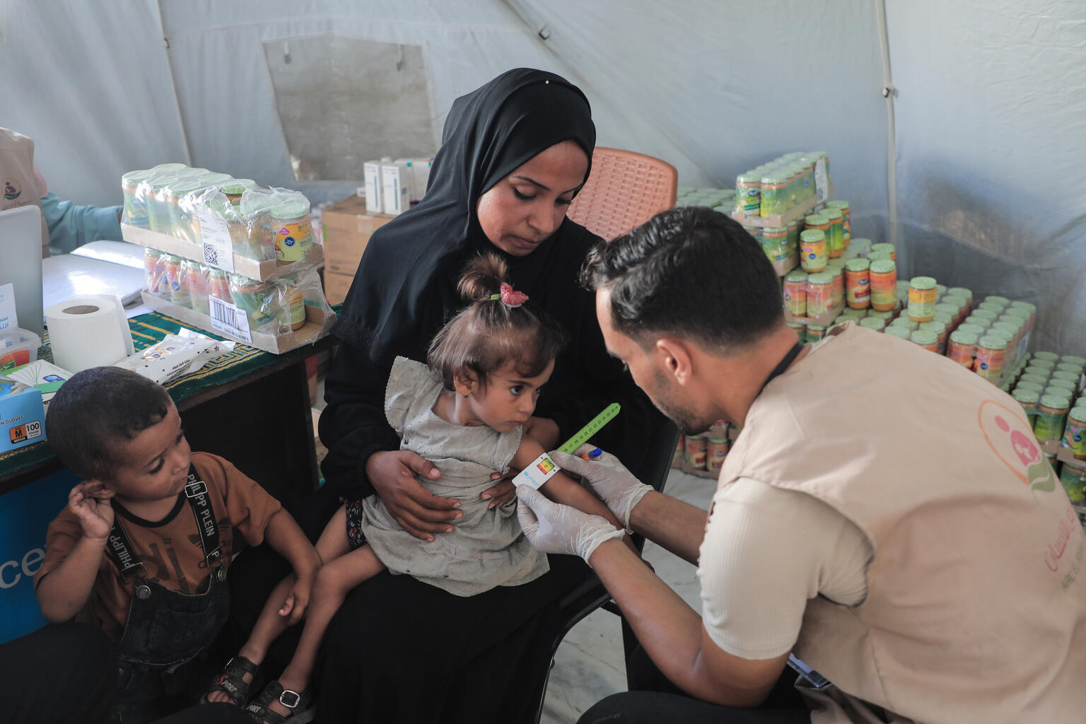 niña en Gaza con desnutrición aguda, junto a su madre y médicos de UNICEF