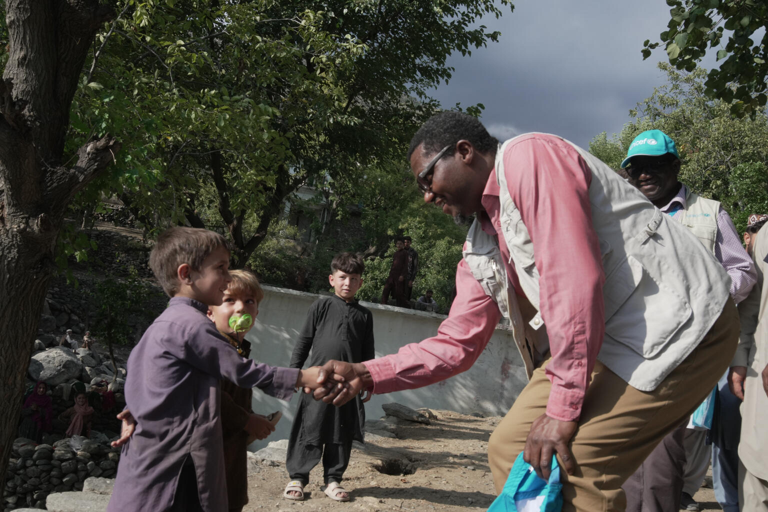 El Dr. Tajudeen Oyewale, representante de UNICEF en Afganistán, da la mano a un niño superviviente de la tragedia