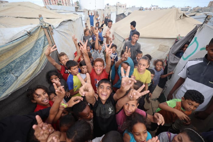 Niños celebran el anuncio de alto el fuego en Gaza.