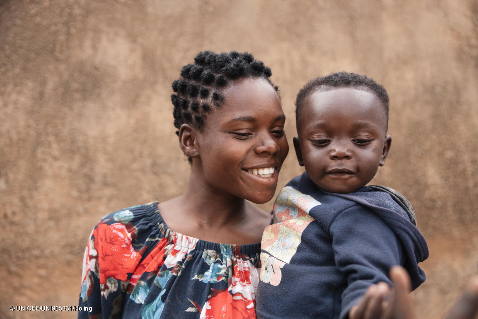madre sonríe junto a su bebé en Zambia