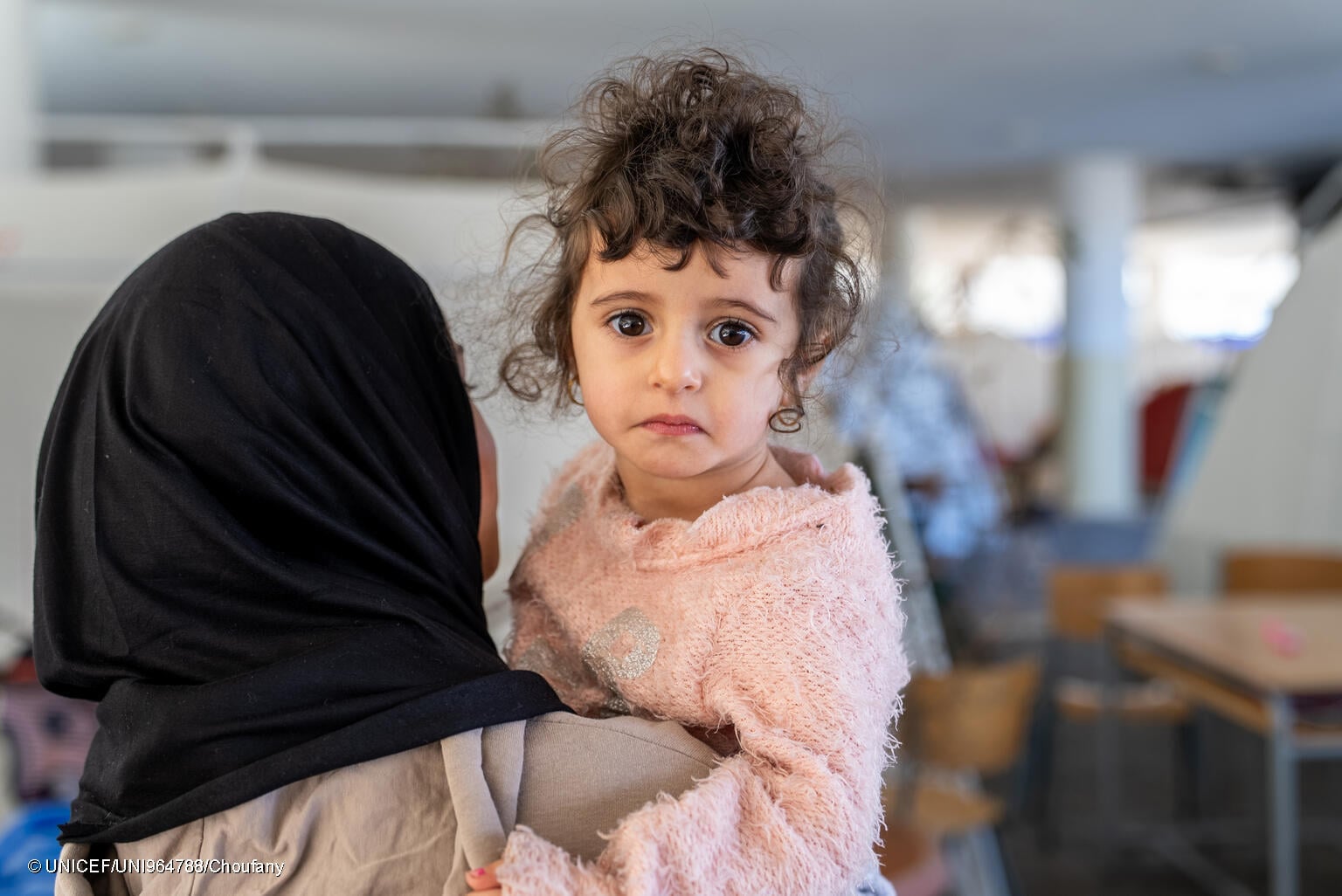 niña desplazada en Beirut, en los brazos de su madre