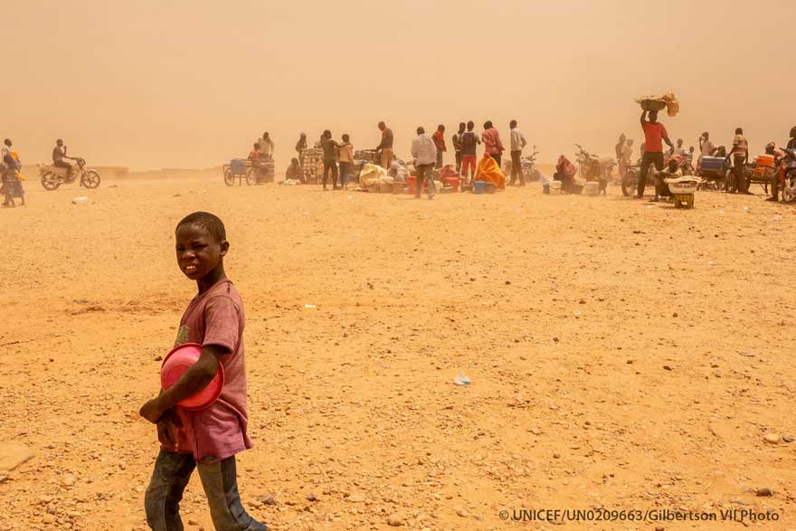 Un niño camina por Níger entre una nube de polvo