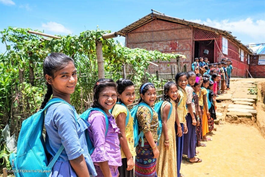 Alumnas rohingya portando mochilas proporcionadas por UNICEF en un campamento de refugiados de Bangladesh