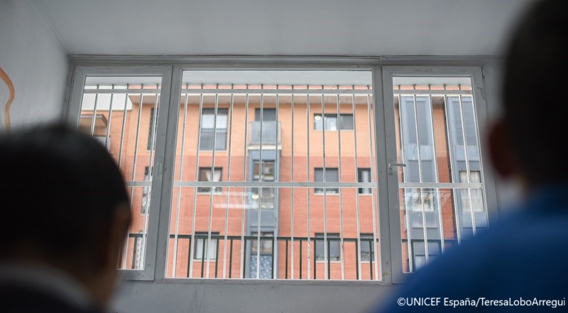 Dos niños mirando por una ventana