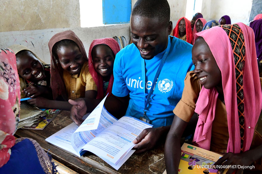 Un miembro del personal de UNICEF lee un libro con unos niños en la escuela municipal de Mongo, en el centro de Chad.