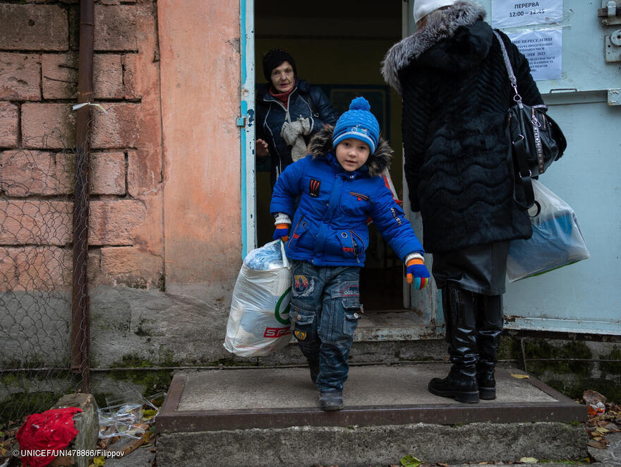 Un niño Ucraniano recoge un kit de prendas de invierno facilitado por UNICEF