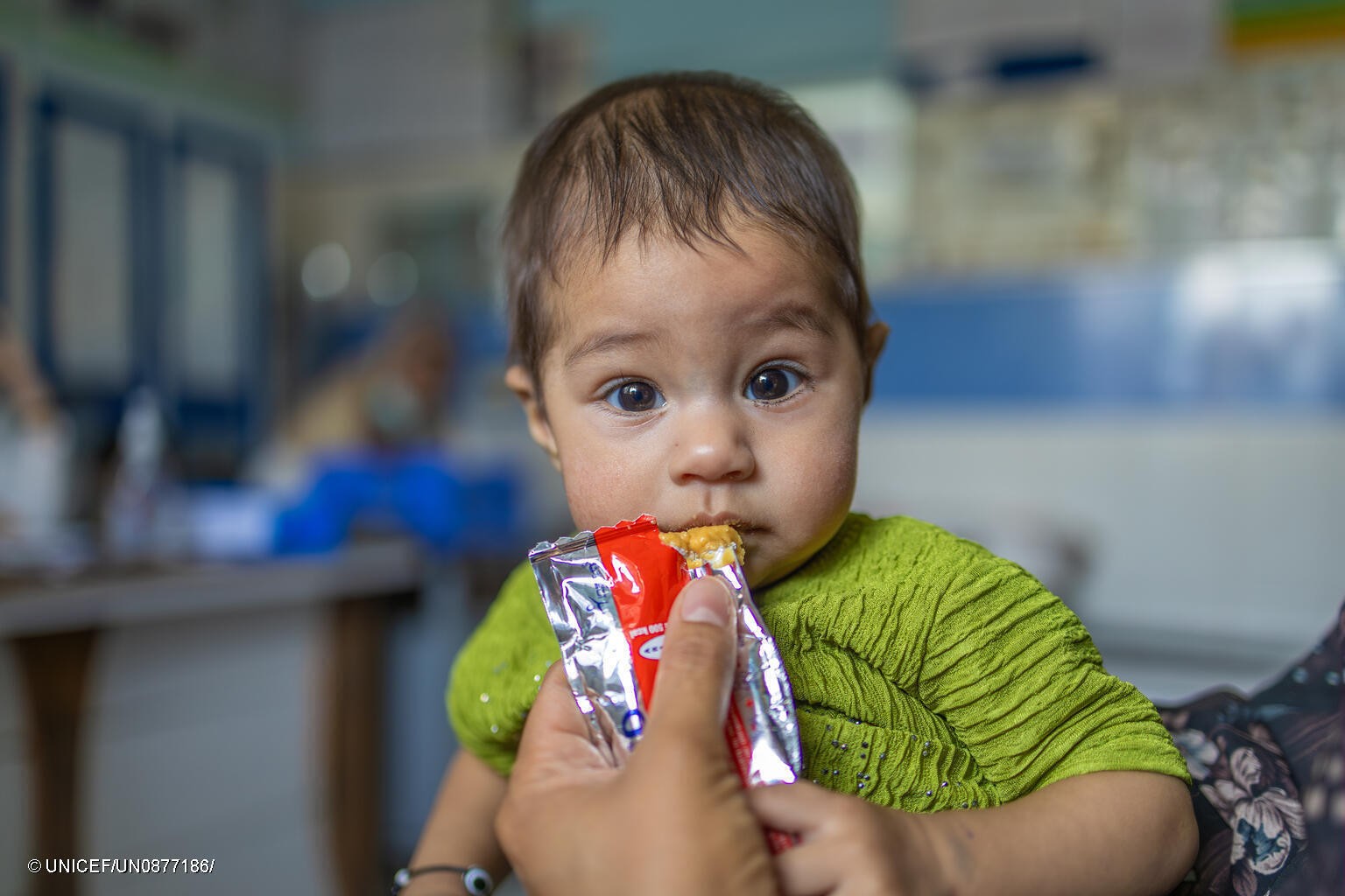 Un niño toma un sobre de alimento terapéutico en Afganistán