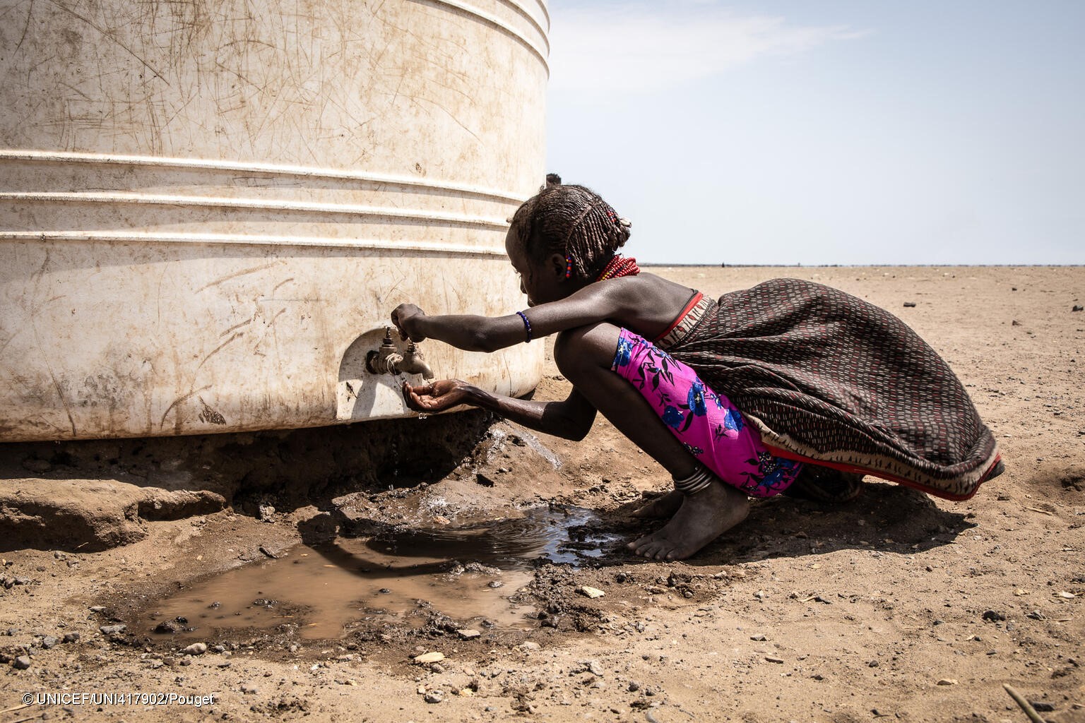 En el distrito de Libemuket, en el sur de Etiopía, afectado por el cambio climático, una niña bebe agua del grifo de un depósito proporcionado por UNICEF en respuesta a la sequía.