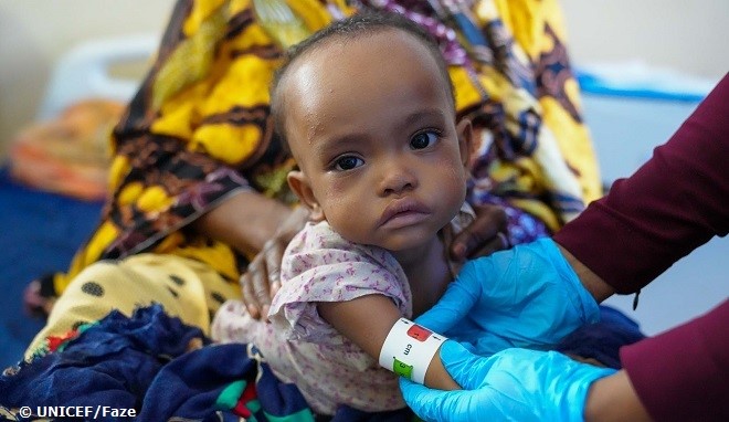 Personal sanitario mide la circunferencia del brazo de una niña