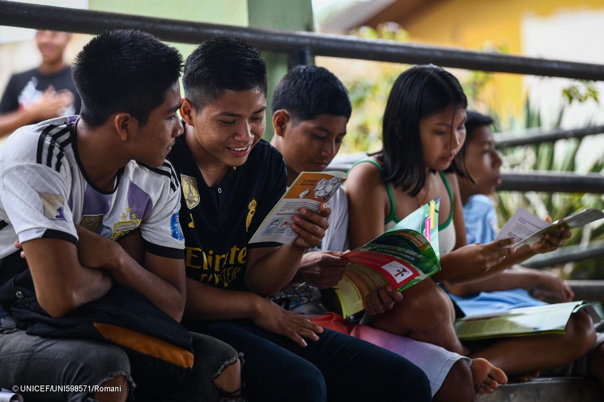 Un grupo de adolescentes leen folletos informativos sobre la prevención del sida