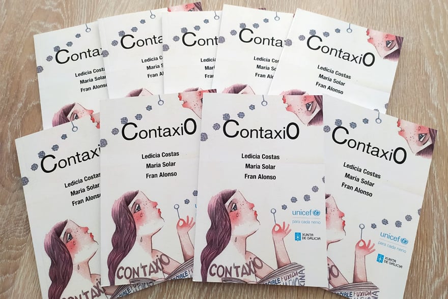 Varios exemplares do conto "Contaxio" sobre unha mesa.