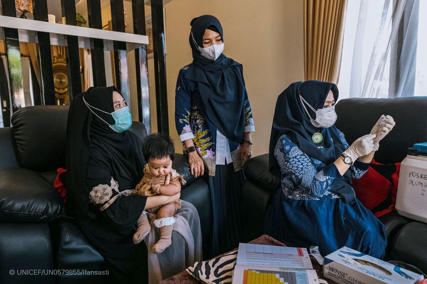 Una enfermera visita a un hogar para vacunar a un niño en Indonesia