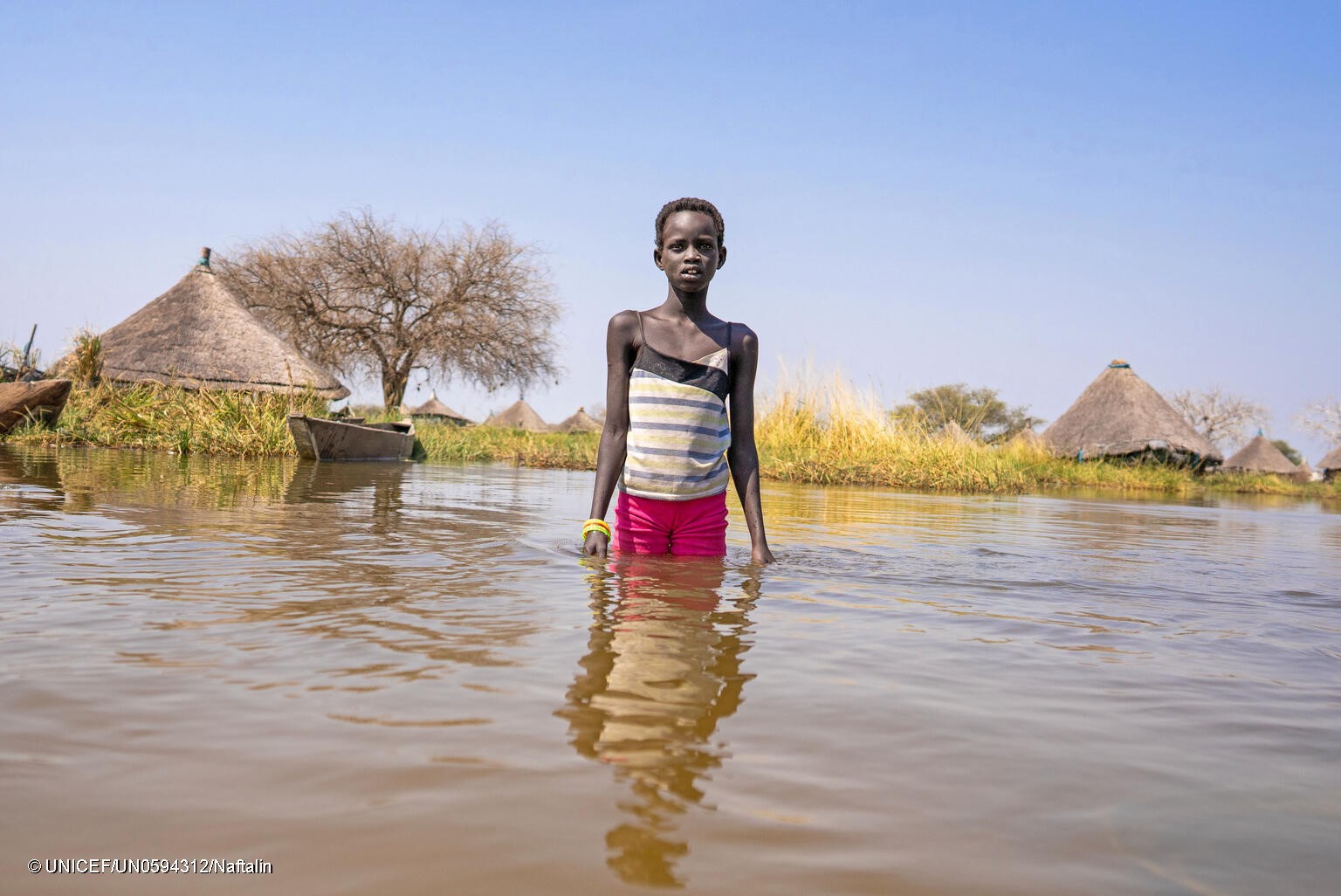 Alekiir Deng Lueth, de 2 años, lava ollas en el agua de la inundación a las afueras de la aldea de Panyagor, en Twic Este, estado de Jonglei, en Sudán del Sur.