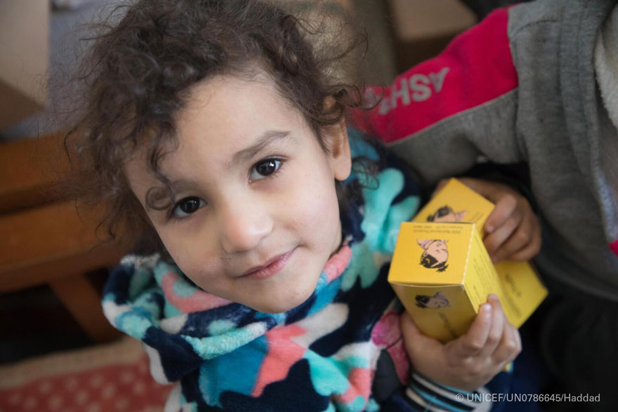 Una niña sostiene cajas de suplementos nutricionales suministrados por una clínica apoyada por UNICEF en Siria.