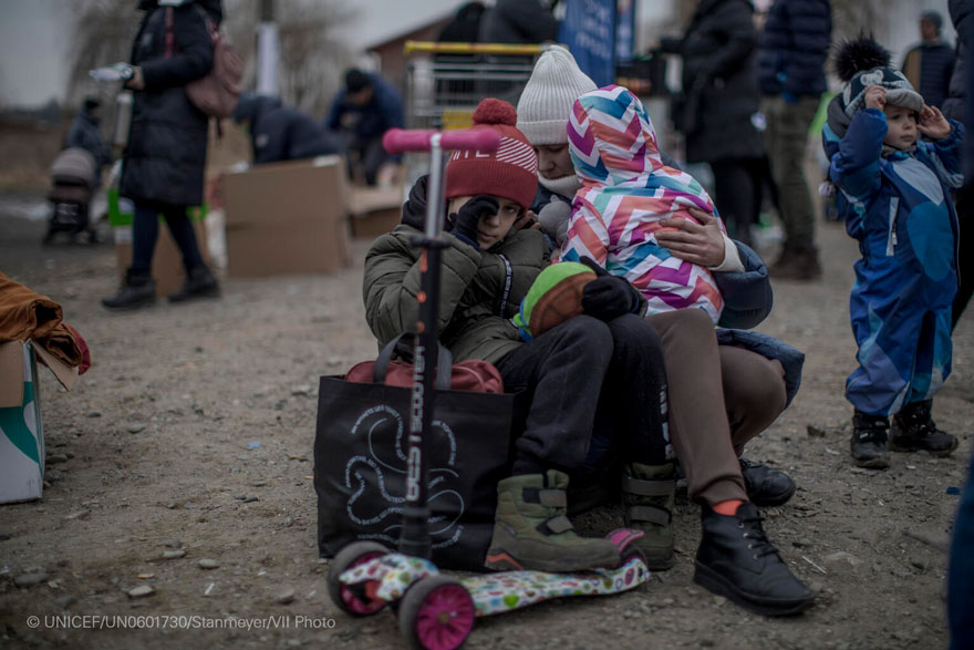 Una madre sentada con sus dos hijos después de llegar a Polonia desde Ucrania