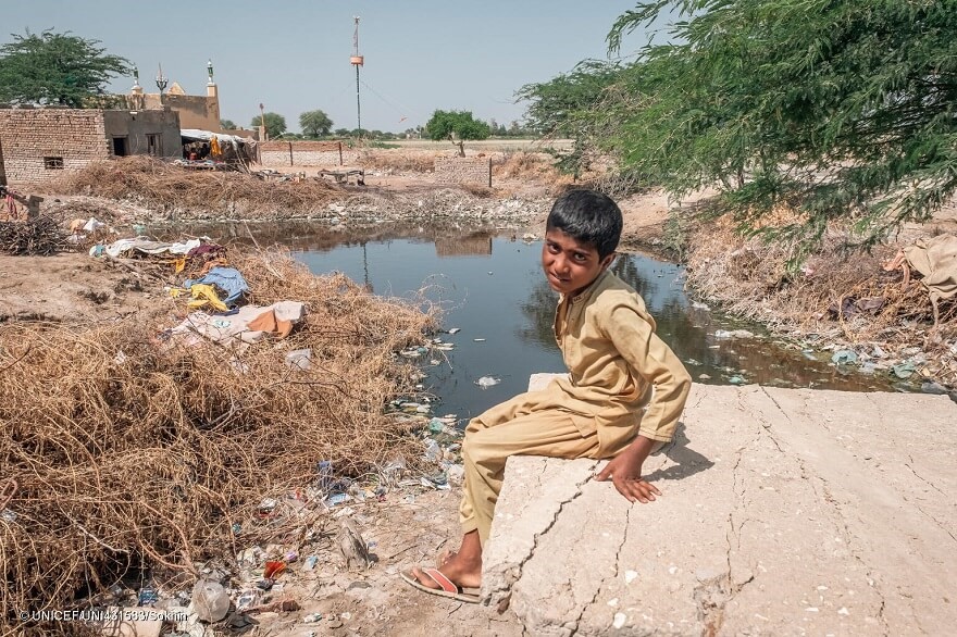 Mukaddar, de 10 años, sentado cerca de una zona inundada de su aldea de Geokaloi, en la provincia meridional paquistaní de Sindh.