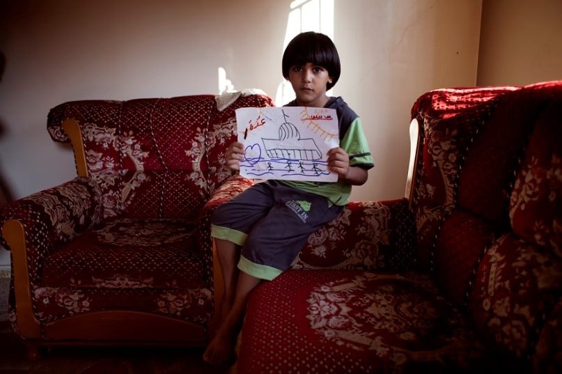 Un niño muestra un dibujo en Palestina