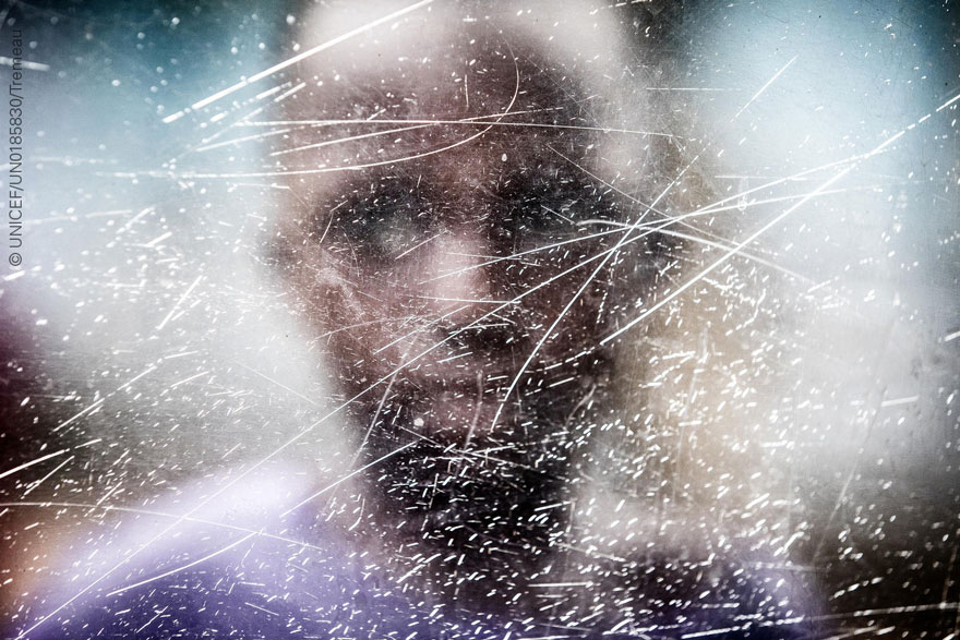 Rostro de un niño africano tras un cristal