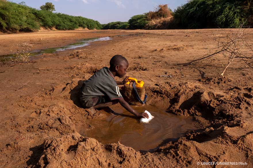 En Somalia, un niño recoge el poco agua que puede de un río seco debido a la grave sequía