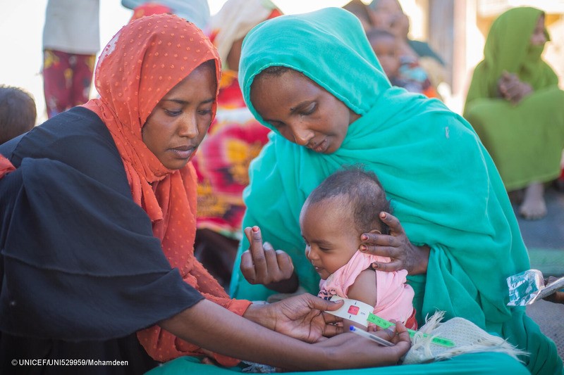 Personal humanitario mide la circunferencia del brazo de una niña pequeña en Sudán