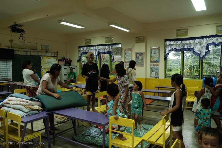 Residentes y familias que se alojan temporalmente en la Escuela Primaria Talao-Talao en Lucena, Filipinas.