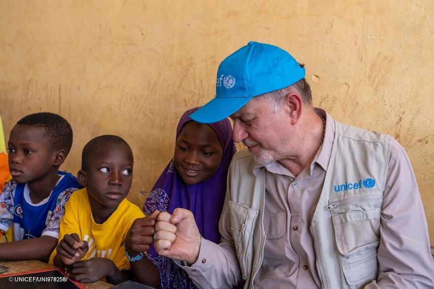 Ted Chaiban choca el puño con una alumna en la escuela Force Vives en Dori, Burkina Faso