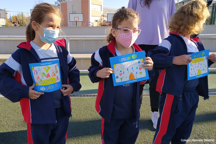 Unas niñas muestran sus dorsales decorados para la carrera del agua de UNICEF