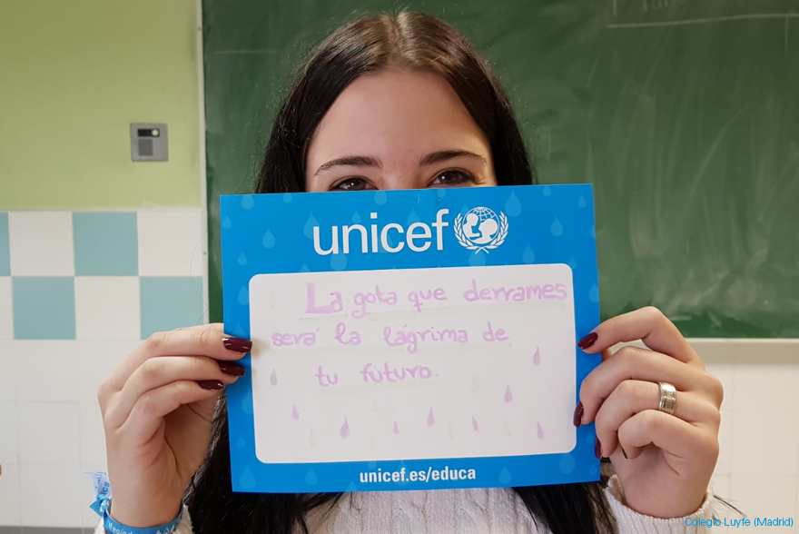 Una chica muestra su dorsal de la carrera de gotas de UNICEF, en el que ha escrito un mensaje