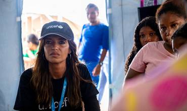 Sara Carbonero escucha atentamente las historias de los migrantes, en un espacio seguro de UNICEF