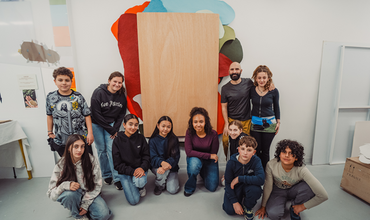 el artista junto a niños y niñas con su obra