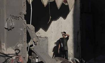 Niño observa los escombros desde su casa derruida en Gaza
