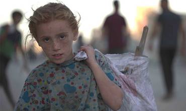 Una niña en Gaza acarrea una bolsa con sus pertenencias