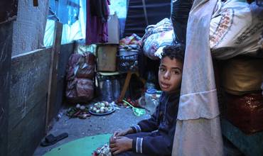 El 19 de diciembre de 2023, Mohammed, de 10 años, está sentado en la tienda improvisada de su familia en un refugio para desplazados internos en Rafah, al sur de la Franja de Gaza. 