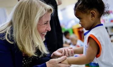 La directora ejecutiva de UNICEF saluda a una niña pequeña durante su visita a Brasil